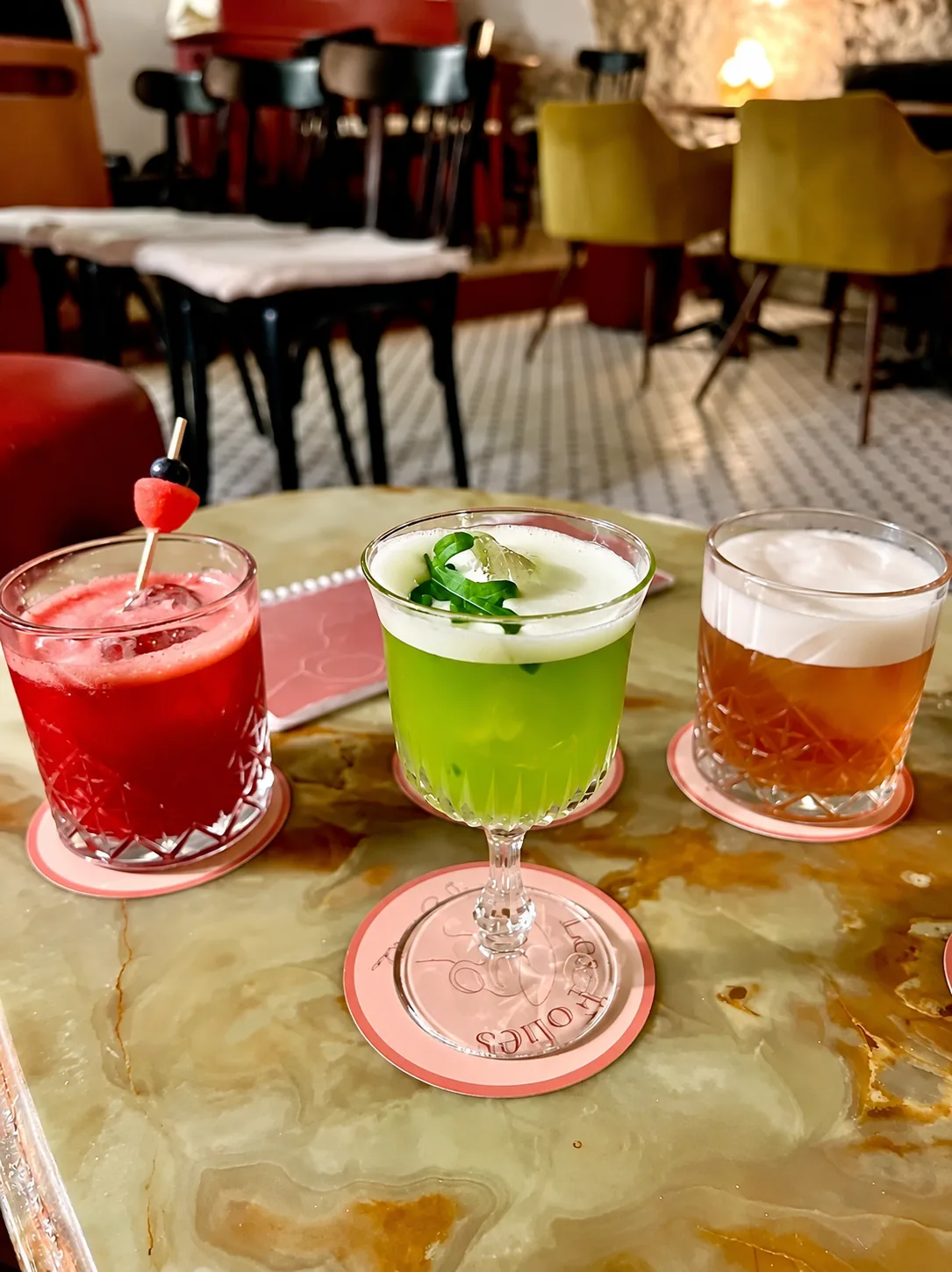 Les Folies d’Edmonde 大理石桌上的三杯鸡尾酒，经修饰的照片